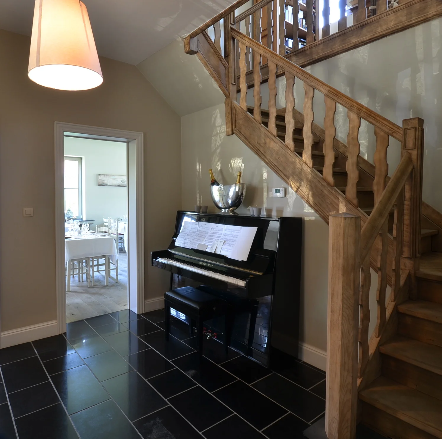 De piano en de houten trap in het onthaal